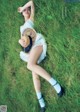 A woman laying in the grass with a straw hat.